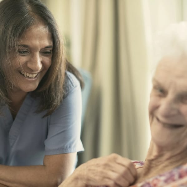 A carer smiling with an older woman